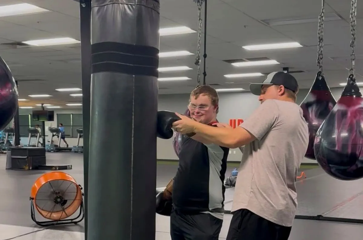 A coach helping an athlete train on the heavy bag at Valor Fit Society