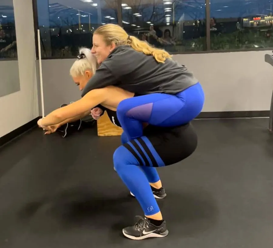 A coach helping a member with kettlebell hip-hinge form